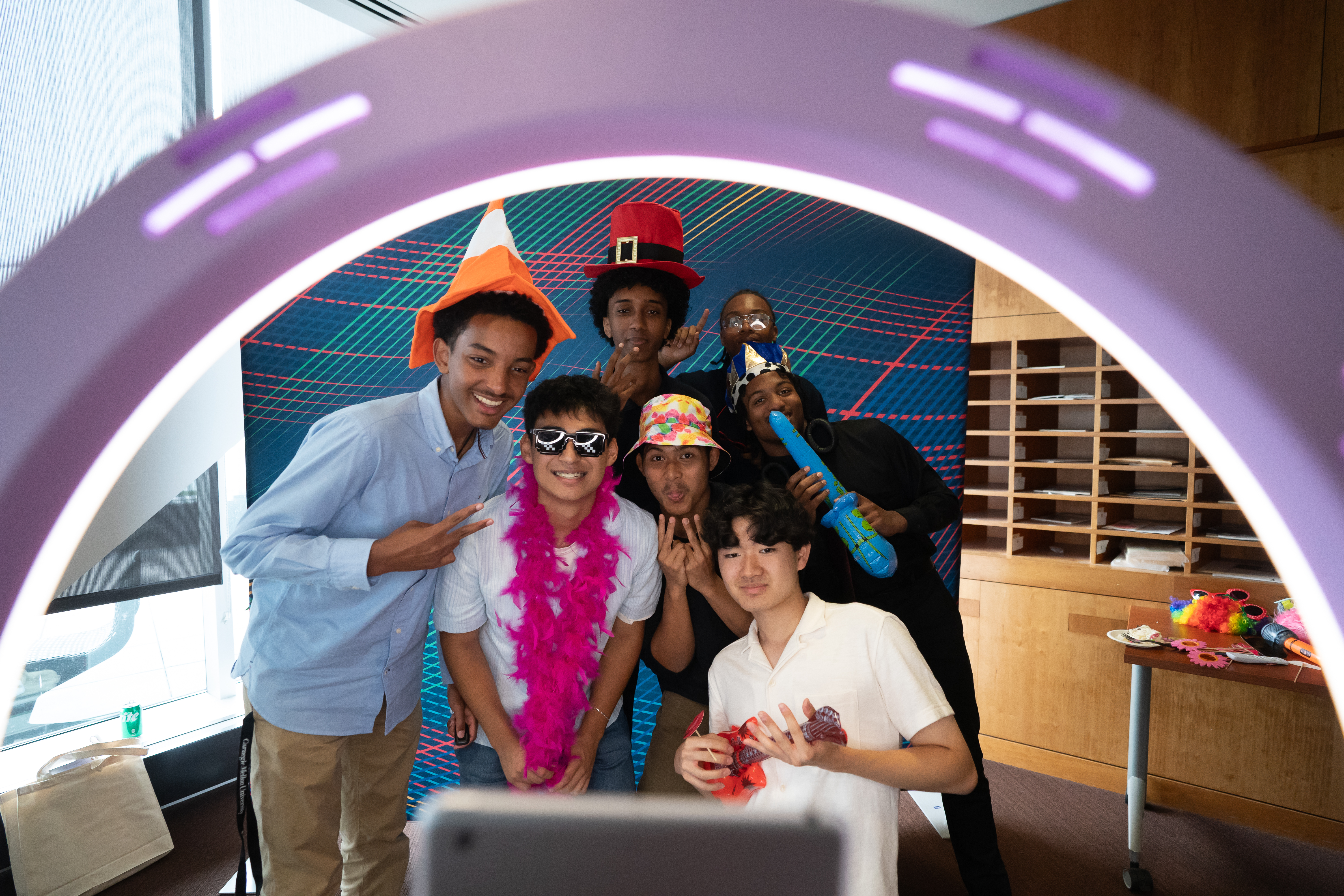 AI Scholars students posing with props at Symposium photobooth