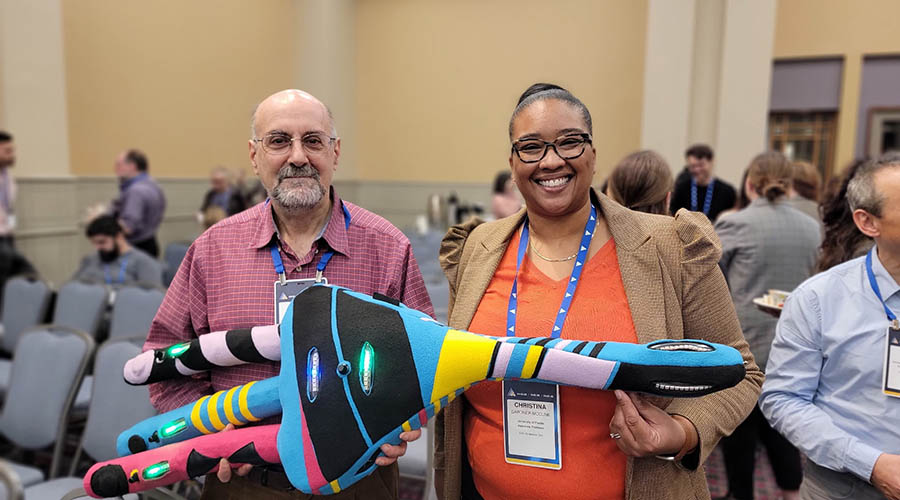People pose with a plush neuron