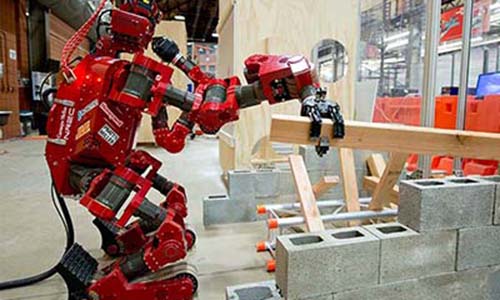 a photo of Carnegie Mellon University's CHIMP — the CMU Highly Intelligent Mobile Platform robot moves a board over concrete blocks.