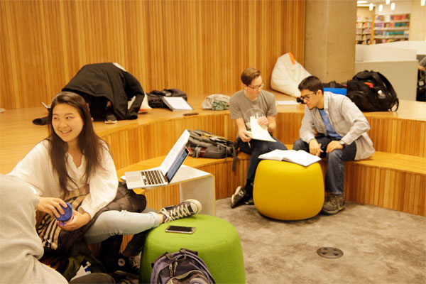 Students sitting in the library studying and chatting