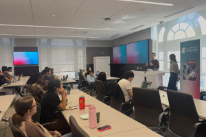 Speakers at the front of a room of students