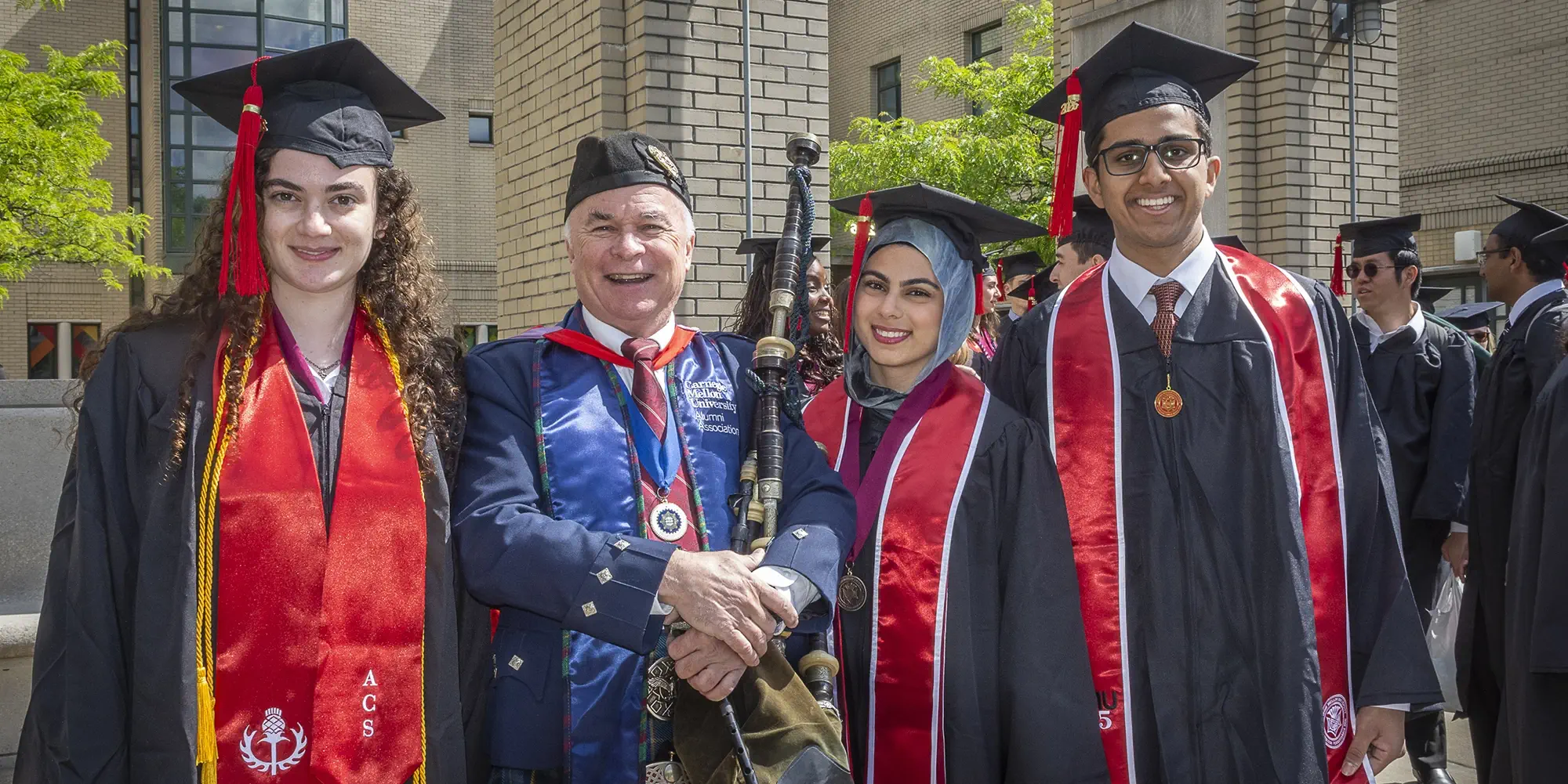 Phi Beta Kappa students pose with a bagpiper