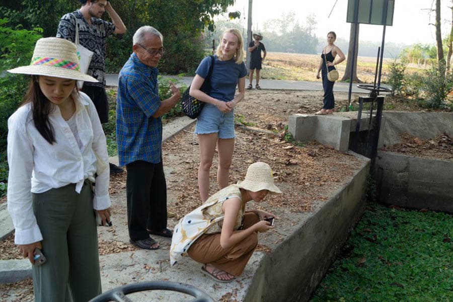  Students walk through a village with Phaw Pheeyin, who tells them about the canal systems and their upkeep. (Tommy Yang, January 2020)