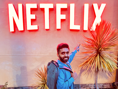 Anish Menon in front of an illuminated Netflix sign