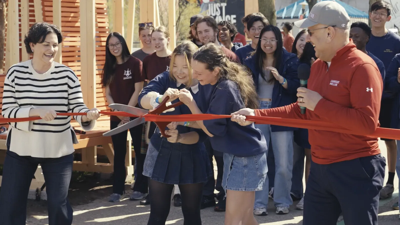 students and administrators cutting the ribbon to open Carnival 