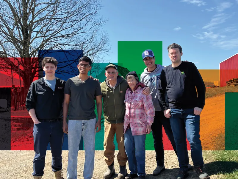 The group standing in front of colored blocks and a blue sky in winter.