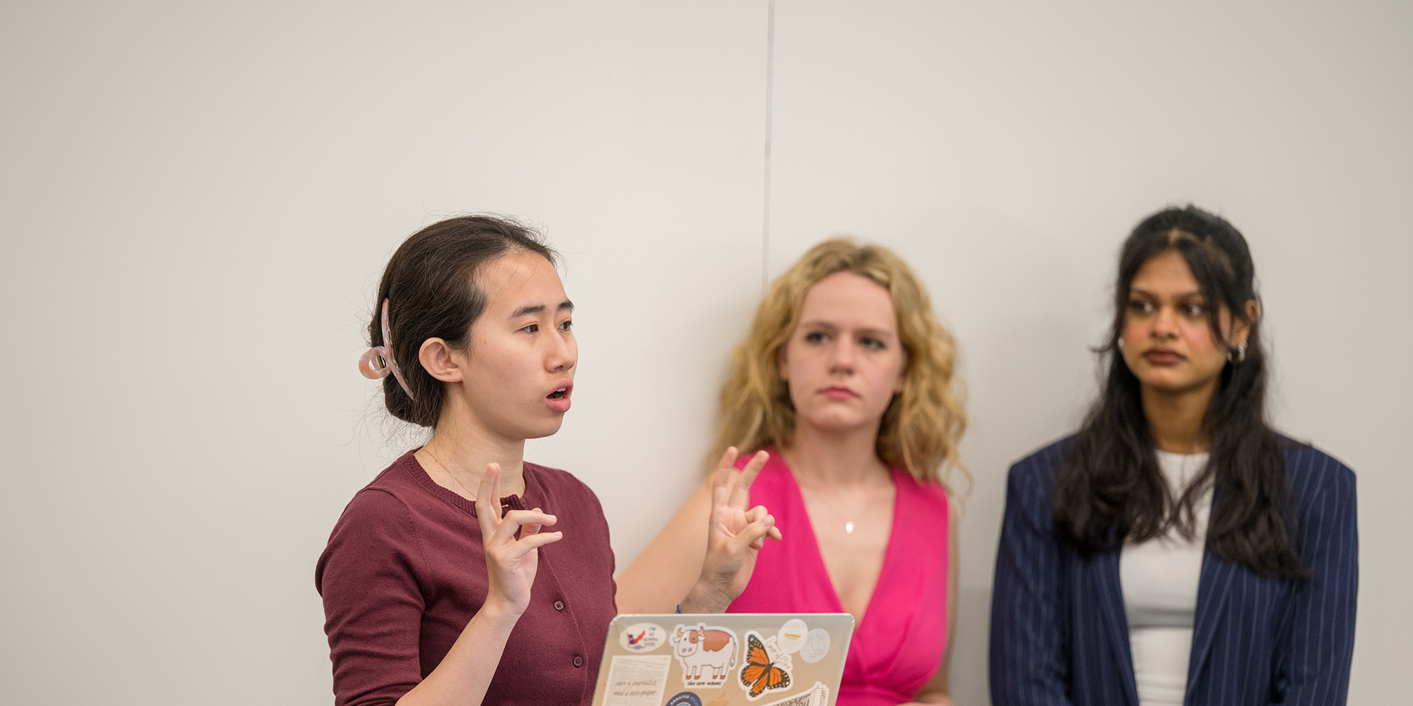 Yaning Wu delivers part of a capstone presentation as Sophia Kurz and Ananya Chembai watch.