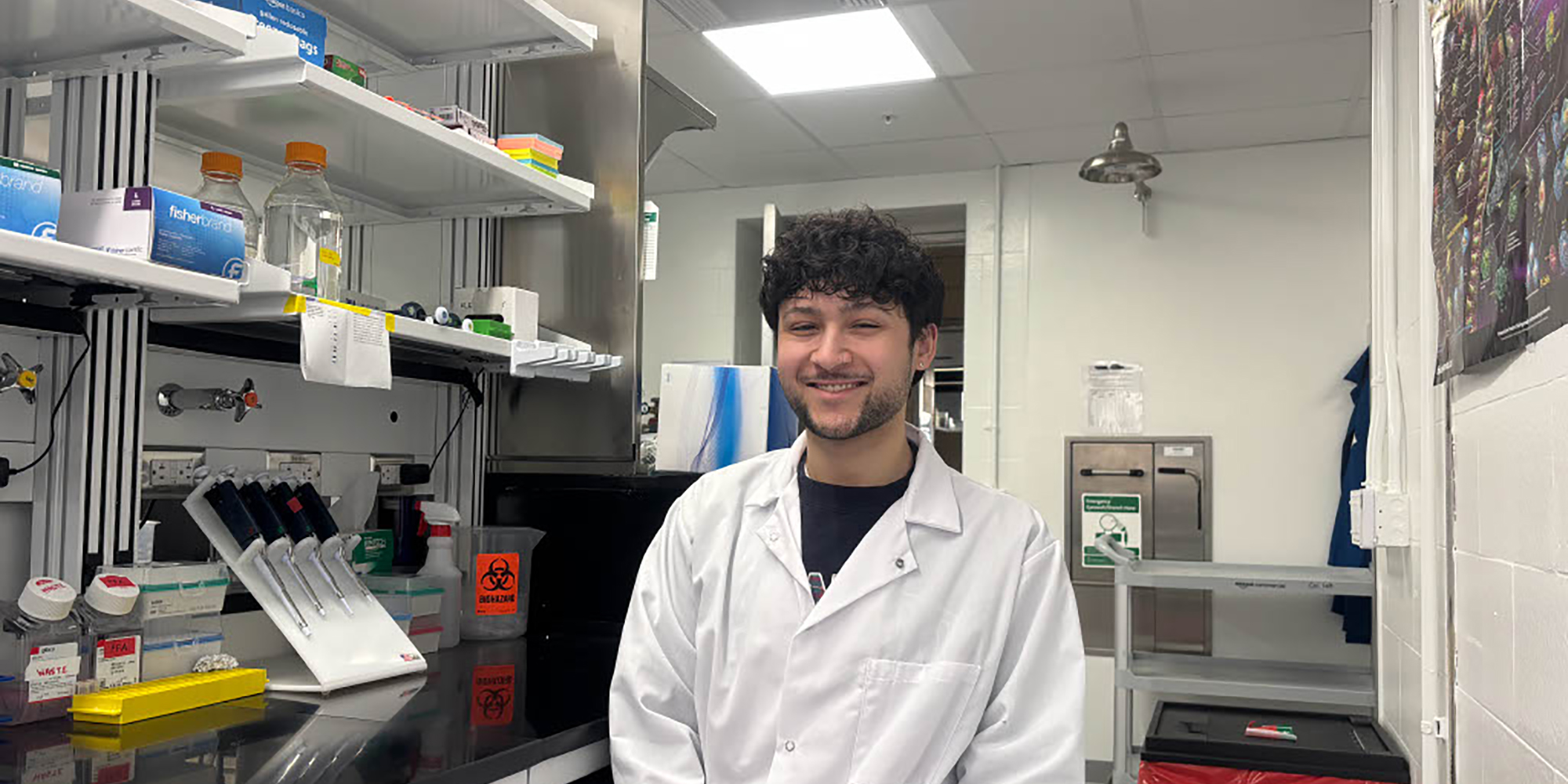 Riley Santiago sits in a biology lab and smiles at the camera.