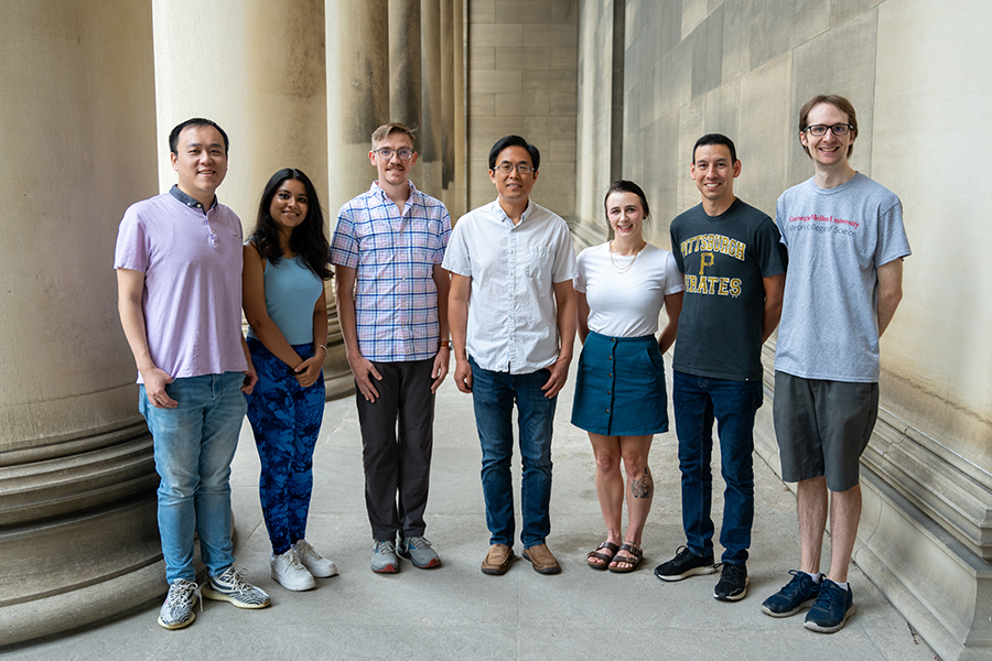 Seven members of the Guo lab stand outside of Mellon Institute.