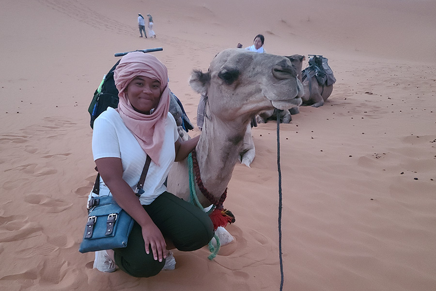 Veronique Wright with a camel in the desert.