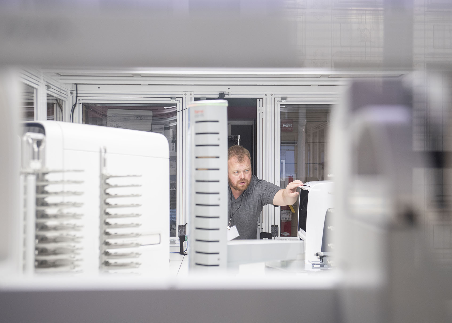 A man looks at racks of white equipment.