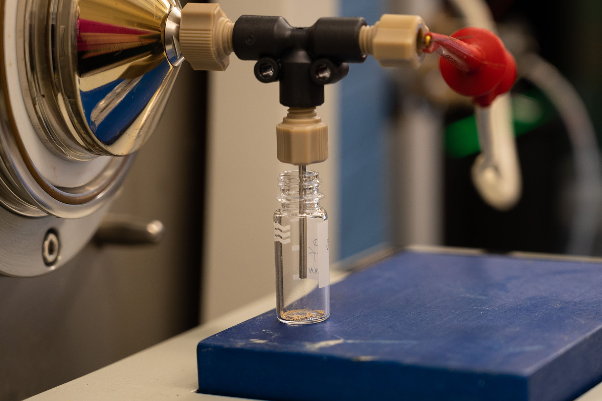 Close-up of a vial on a lab bench in a chemistry laboratory, attached to a scientific equipment.