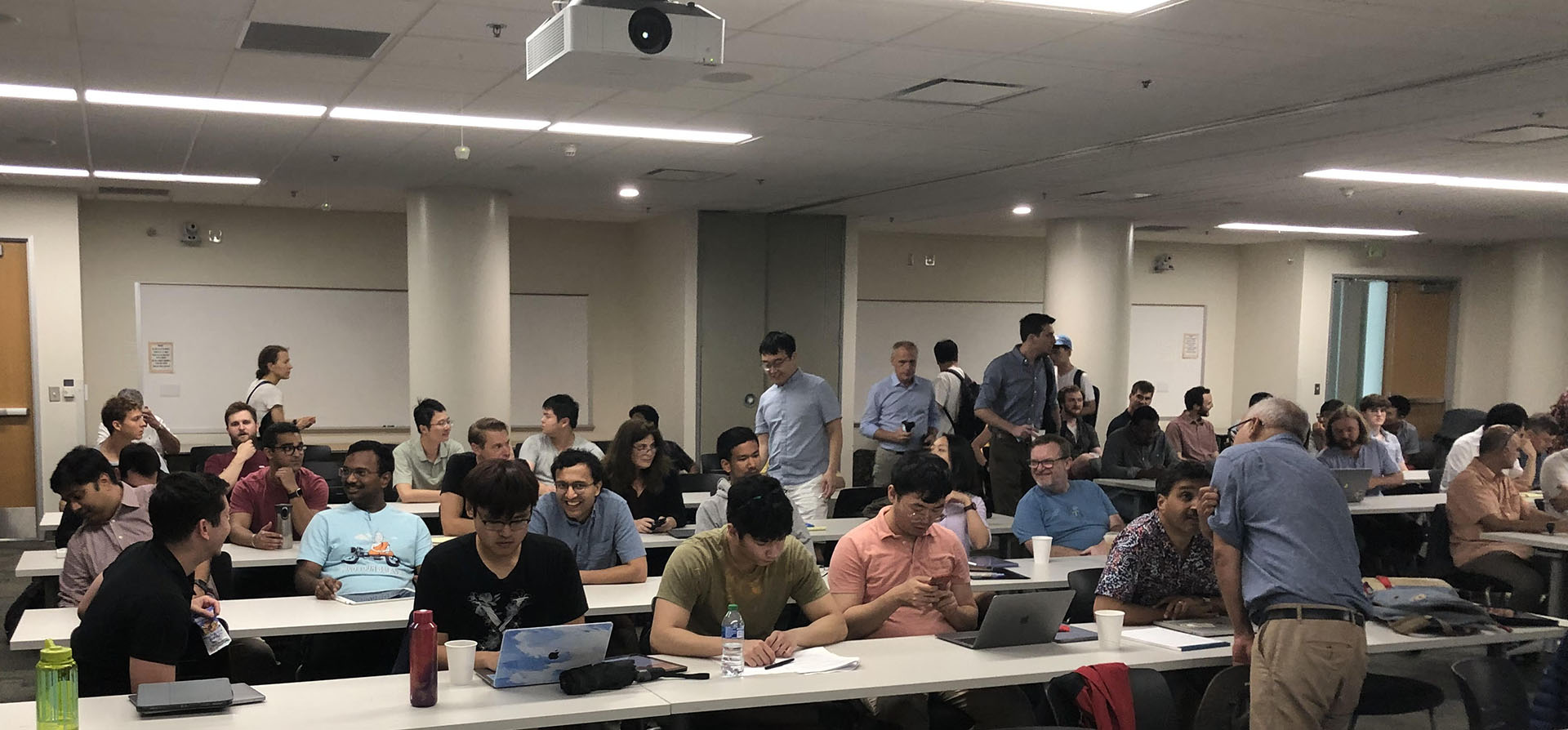 Students relaxing and chatting with each other during a classroom break, sharing smiles and casual conversation.