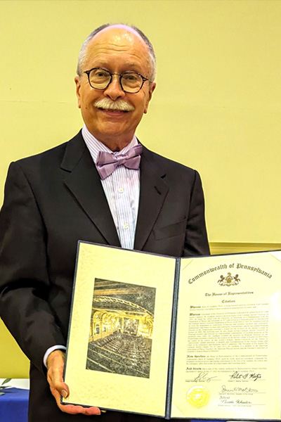 Barry Luokkala holds a document related to PGSS.