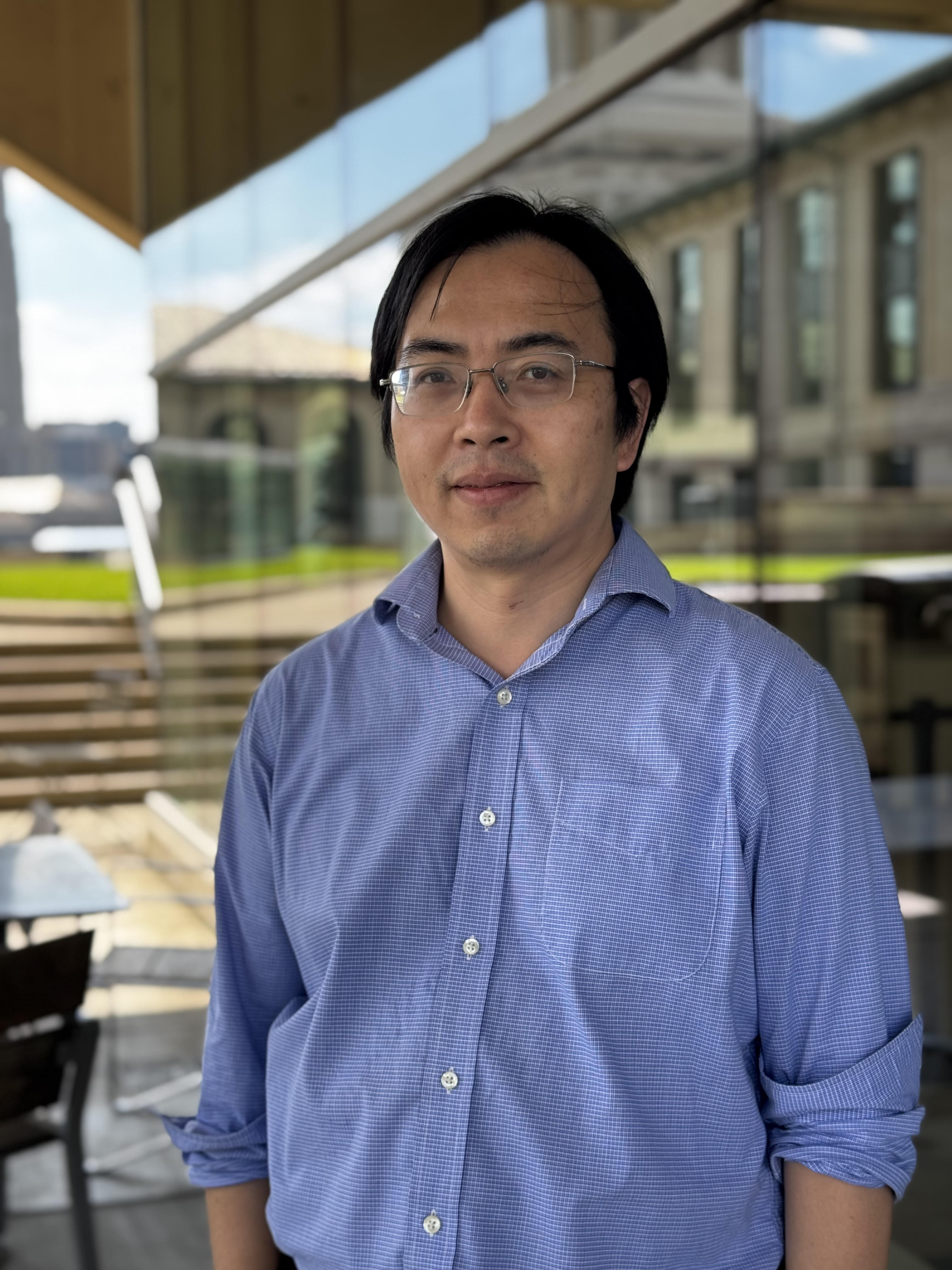Sufei Shi stands outside of Wean Hall and looks into the camera.