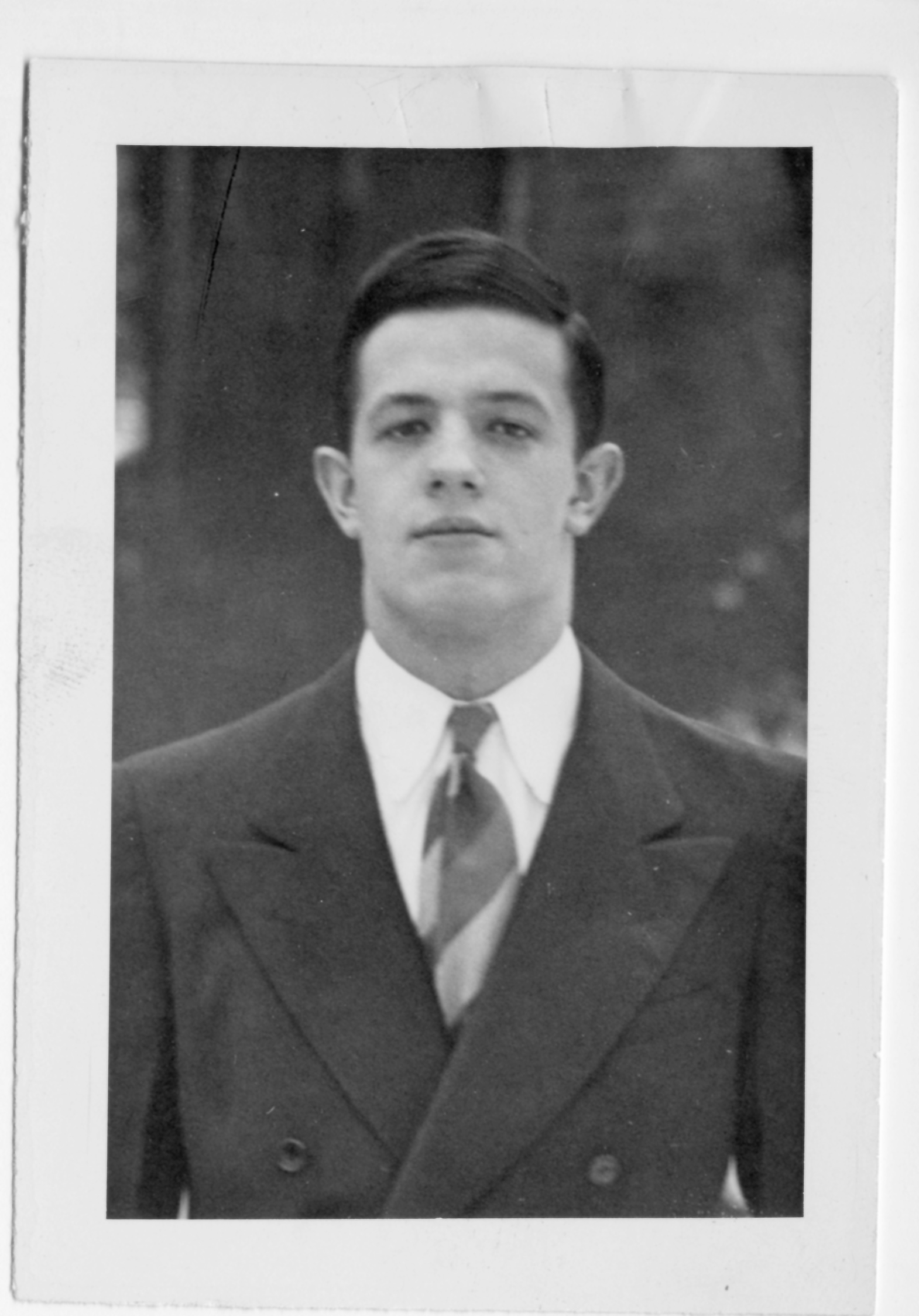 A young John Nash stands outside and looks into the camera.