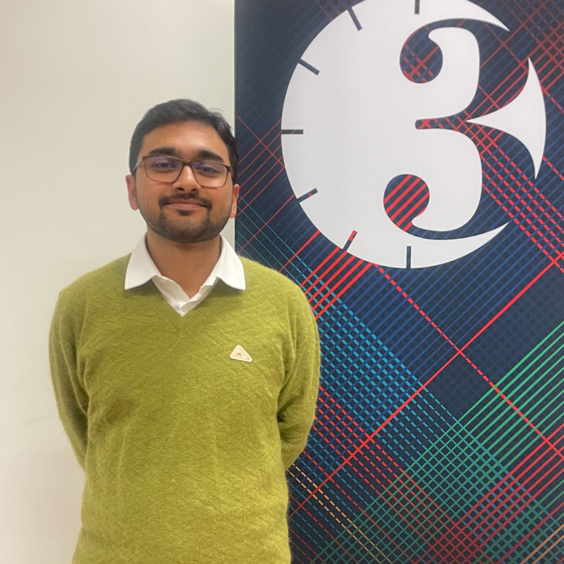 Sunreeta Bhattacharya stands in front of a Three Minute Thesis banner and smiles at the camera.