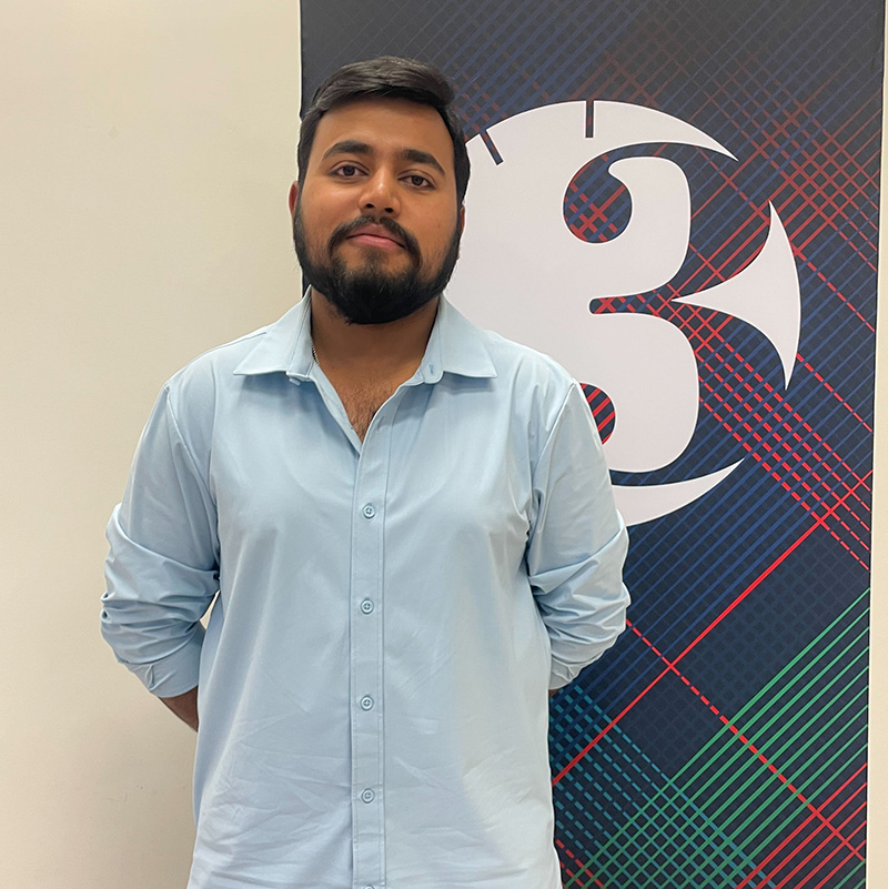 Anish Pyne stands in front of a Three Minute Thesis banner and smiles at the camera.