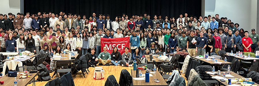 A large group photo of the Market Making Game participants. They hold a banner that says "MSCF."