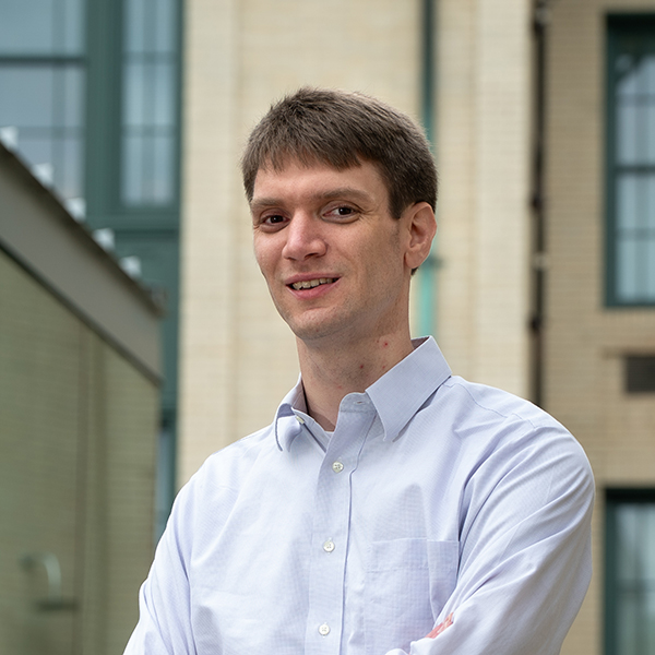 Patrick LaChance stands outside of Doherty Hall and smiles at the camera.