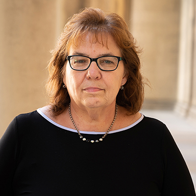Carrie Doonan stands outside of Mellon Institute. She looks into the camera.