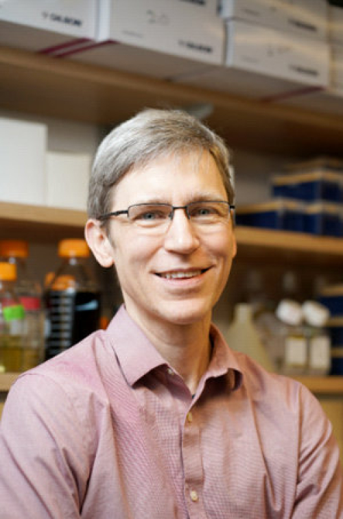 Image of Joel McManus smiling in a lab. 