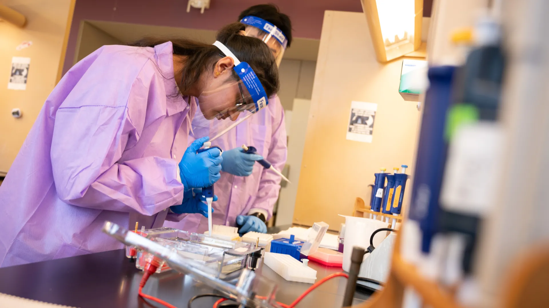 students in lab coats in the bio ID lab