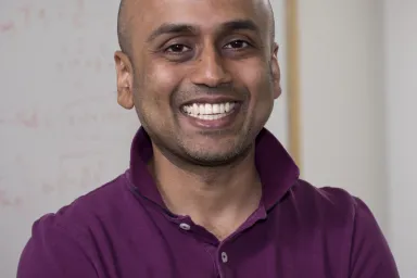 Gautum Iyer - a smiling gentleman wearing a eggplant colored shirt