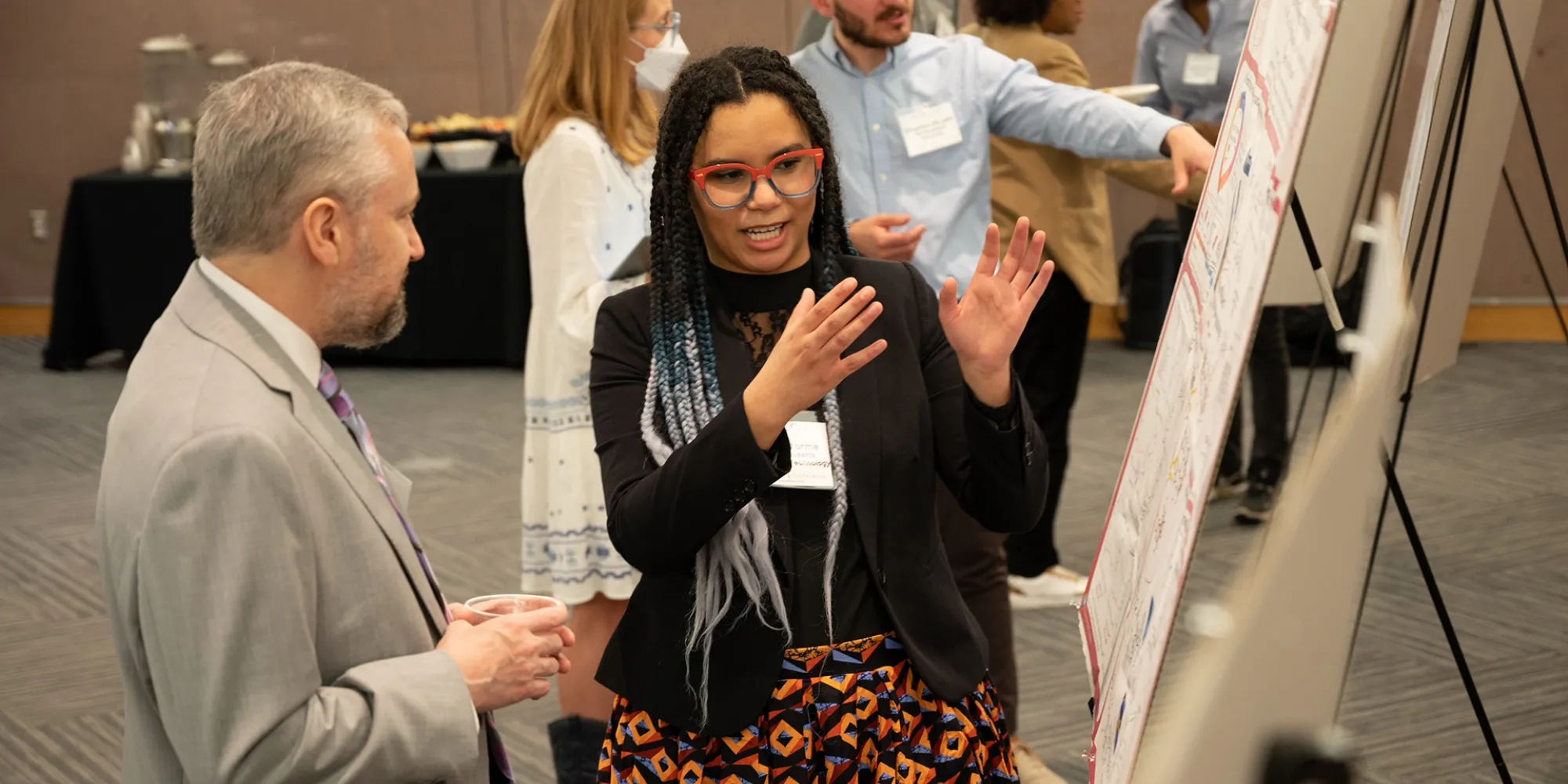 Kayla Storme gives a poster presentation to Bruce Armitage.