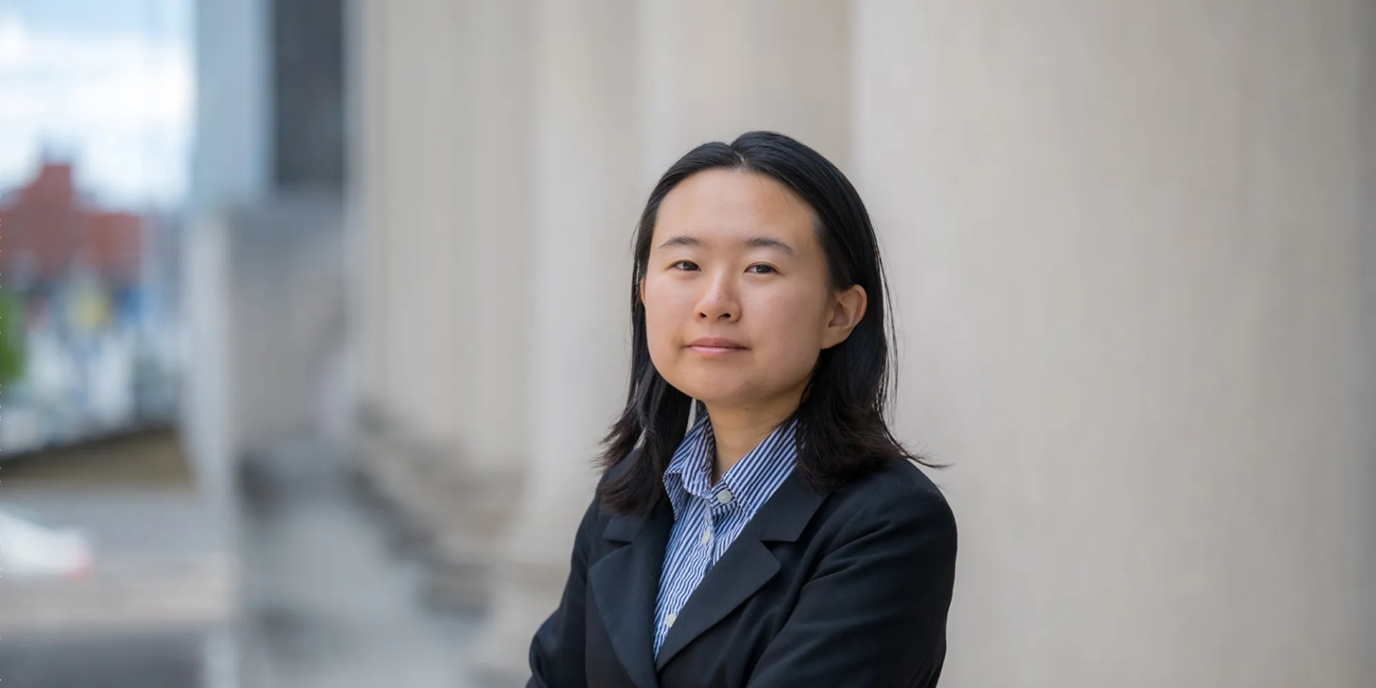 Katherine Wang stands outside of Mellon Institute. She looks into the camera.