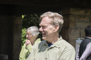 Michael Hendrich stands outside during a retirement party. He smiles at someone off camera.