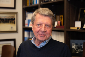 Krzysztof Matyjaszewski posing in his office with a slight smile.