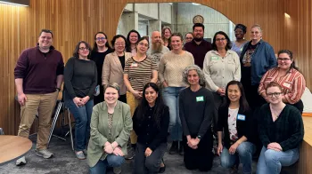 A large group of people poses together for the camera. They are smiling at the camera.