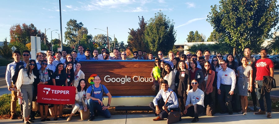 Tepper School students gathered around a Google Cloud office sign.