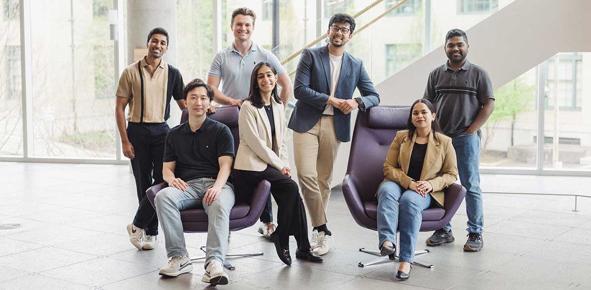 A group of master's students smile at the camera