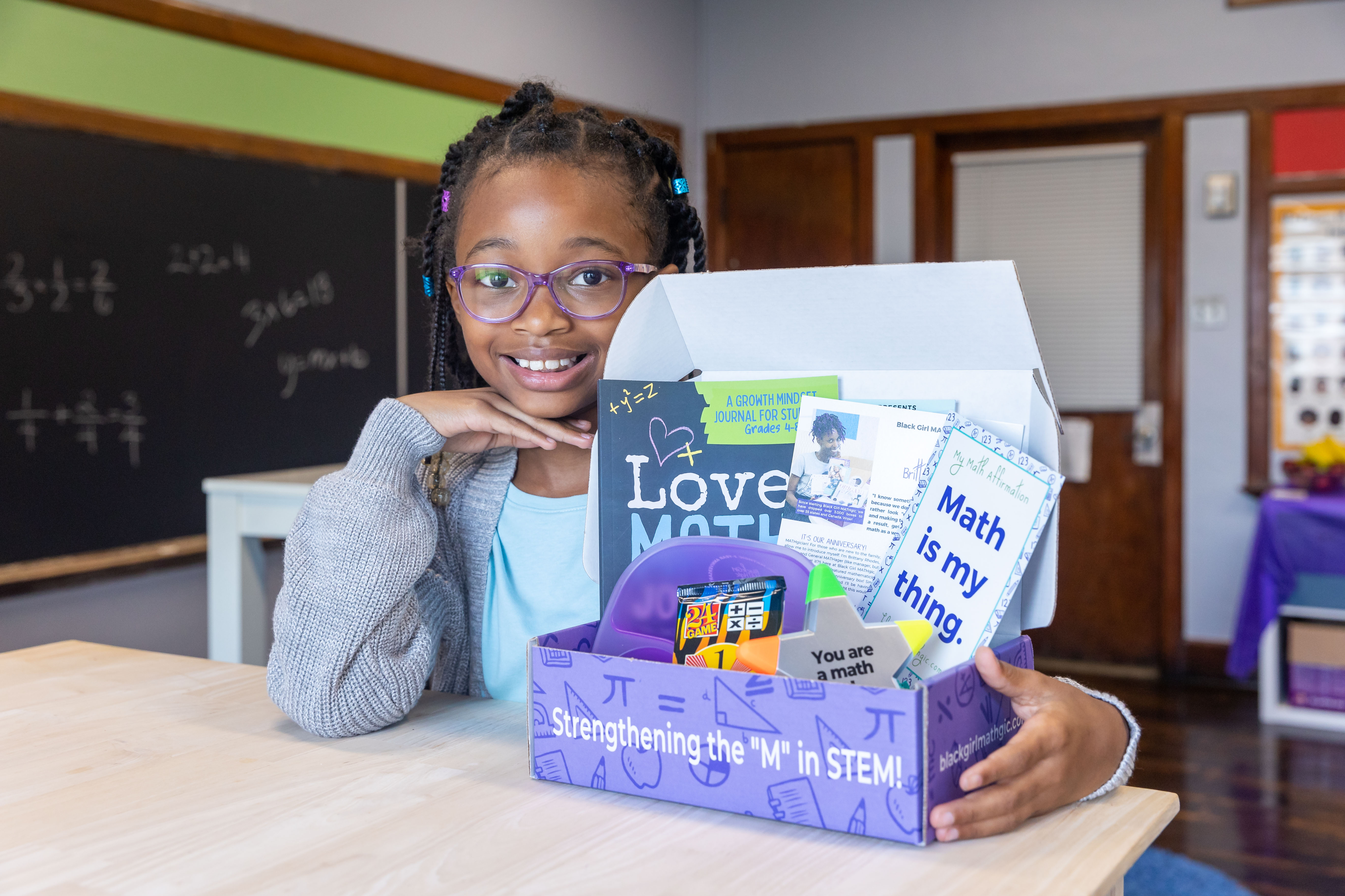 A girl poses with a kit box