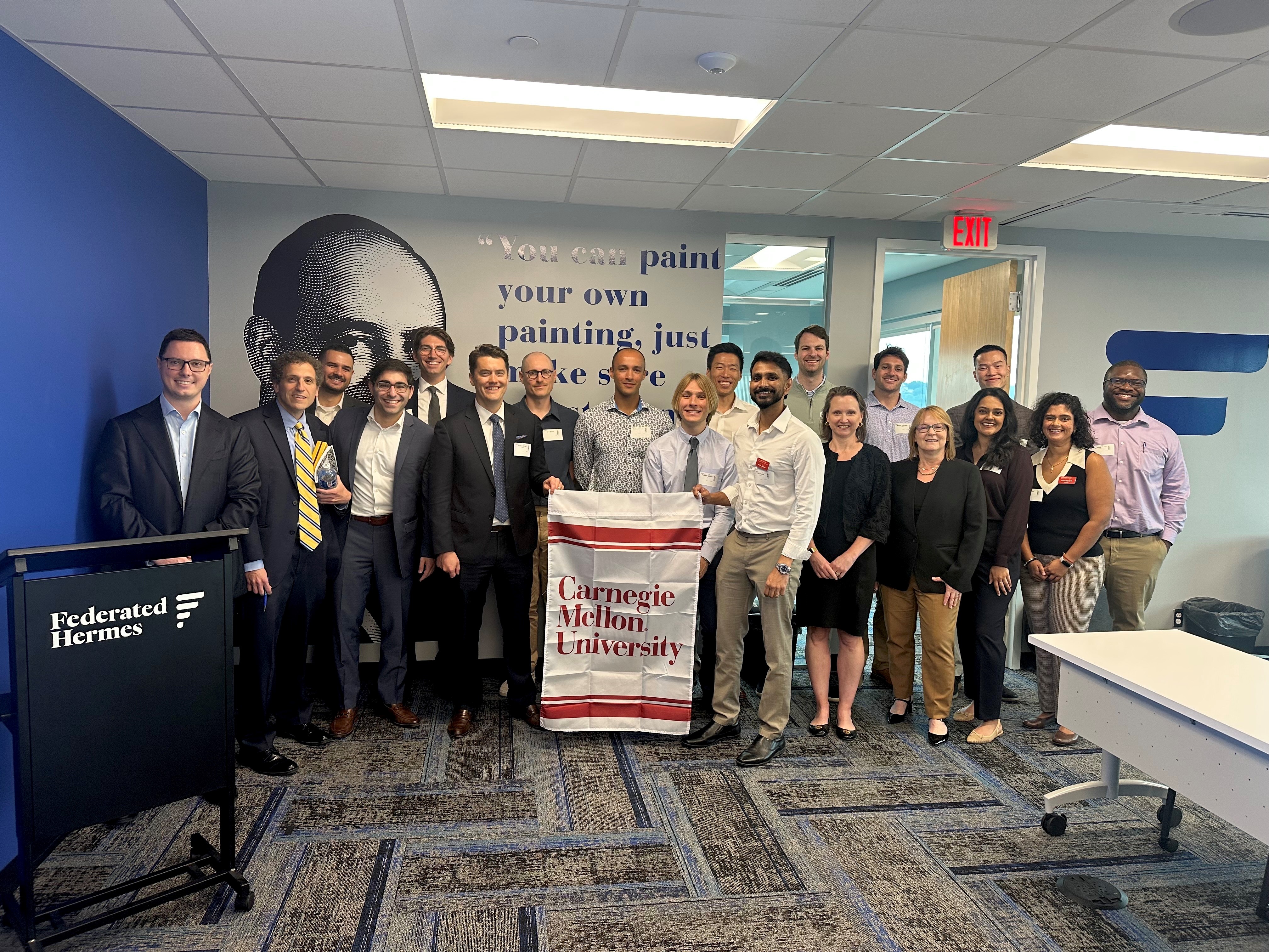 Group at Federated Hermes holding a Carnegie Mellon University flag