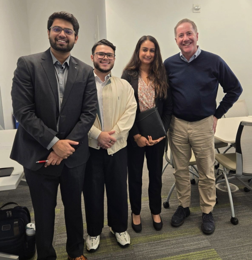 A photo of Chris Leech standing with a group of students