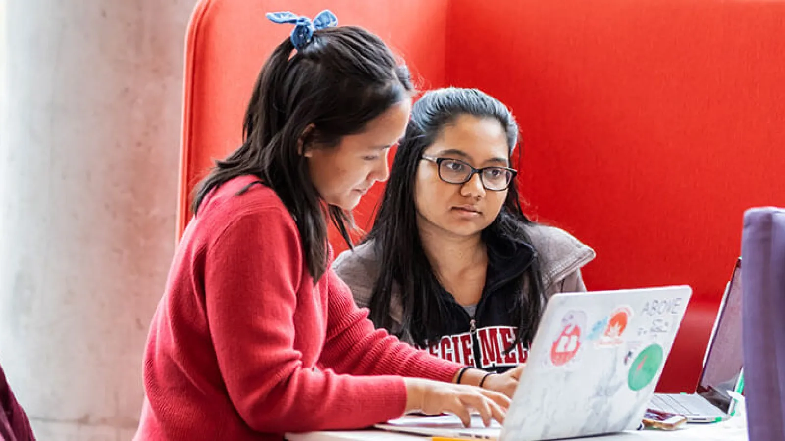 Two students working on laptop computers.