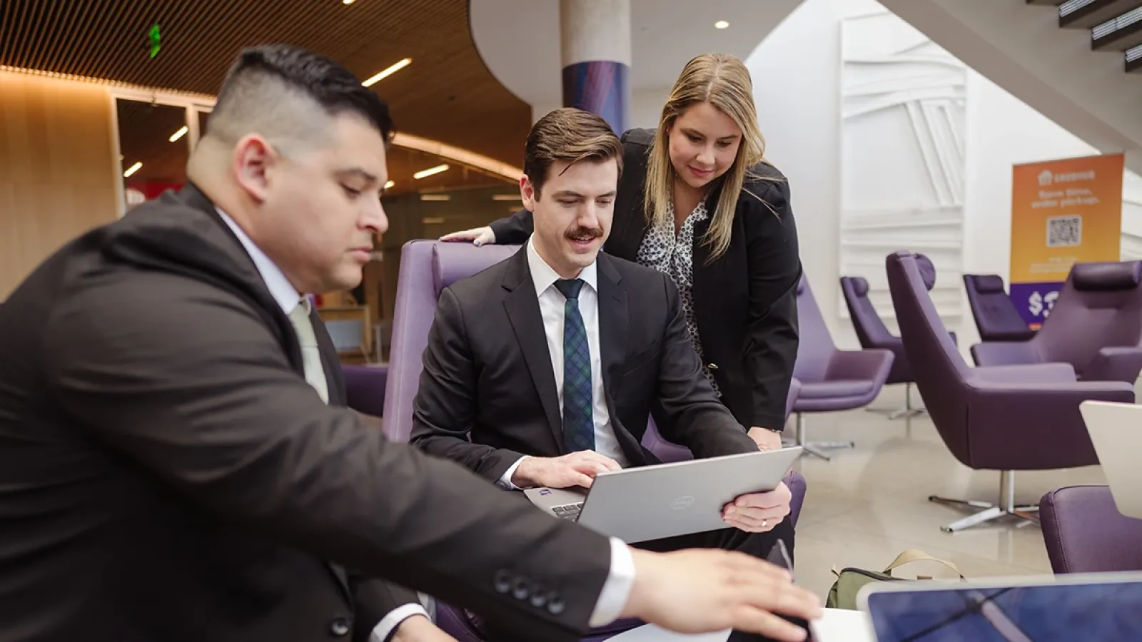 Three Tepper School OHMBA Students looking at a laptop