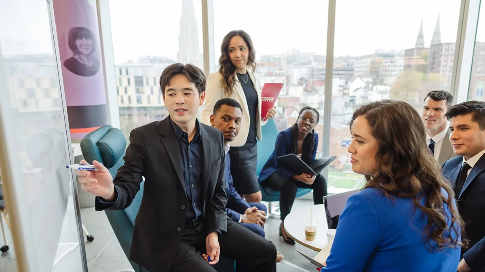 A group of Tepper School MBA's collaborating around a whiteboard.