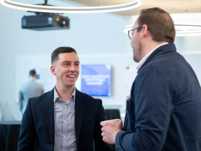 Nathan Edmondson talks with a colleague at the Golub Board Fellows Symposium