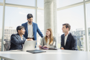 Four people discussing business in a work setting. 