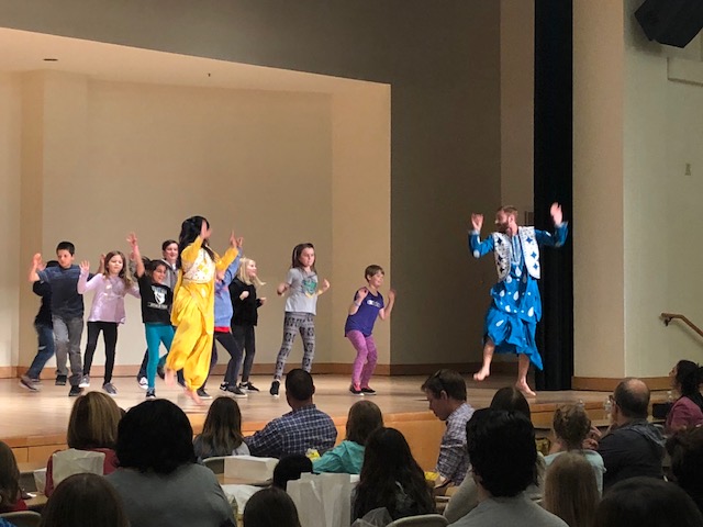 Image of students and children on stage dancing