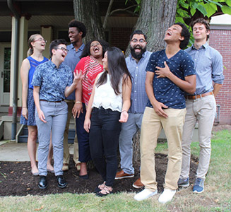 student Community Advisors laughing and smiling under a tree