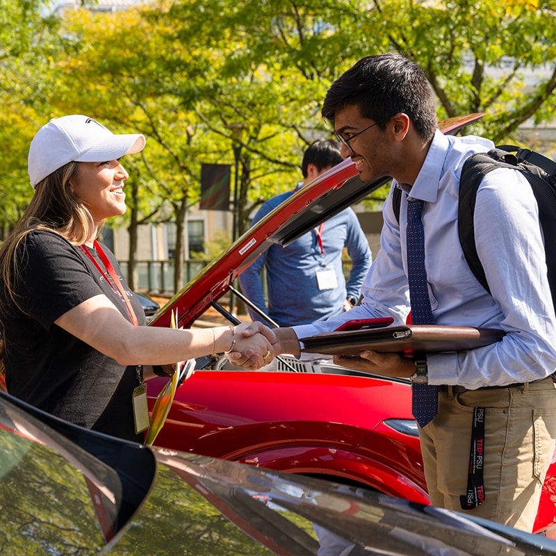 CMUI student shakes hands with an employer at the Career and Professional Development Center's annual Vroom Vroom CMU career fair.