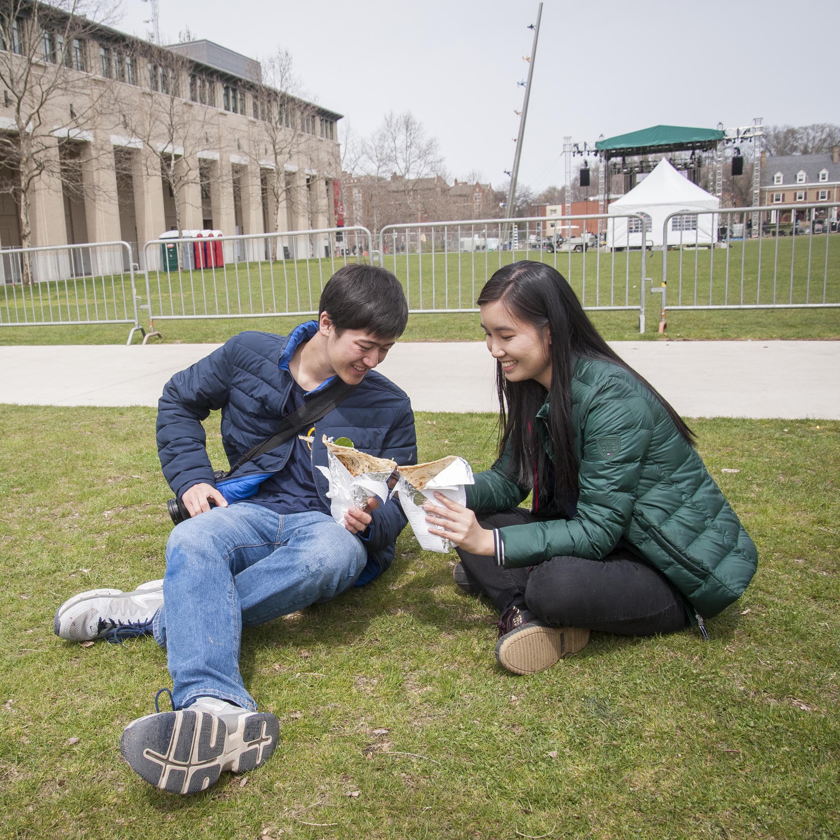 Image of two students sitting on the Cut, eating food