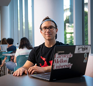 SCS sophomore Abe Riedel-Mishaan sitting in front of his lap top