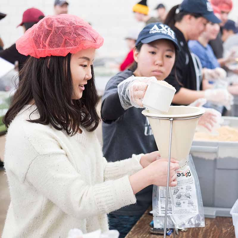 Photo of student packing up food for a charity event