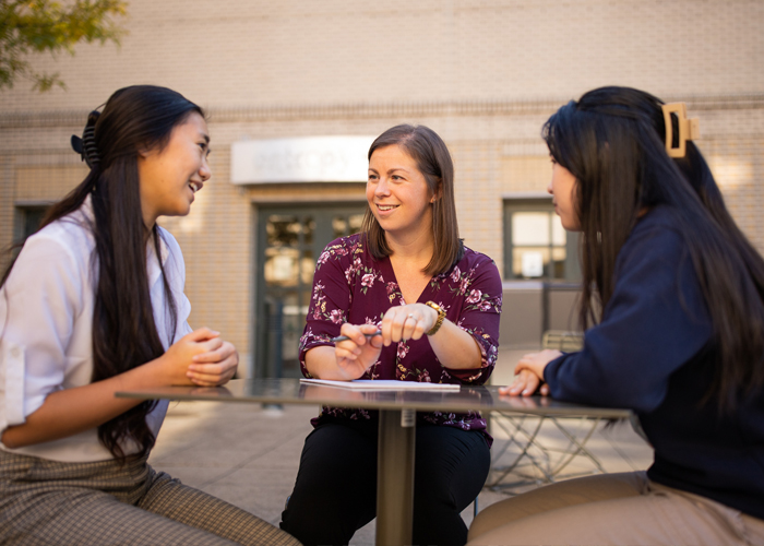 Student Involvement and Traditions Director Elizabeth Koch meets with students in Merson Courtyard